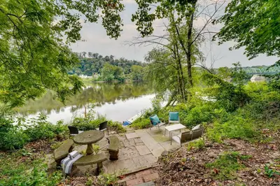 a picnic table and chairs next to a river at Upper Black Eddy Home with Delaware River Access! in Upper Black Eddy