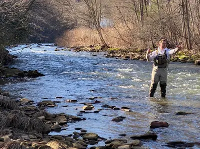 a man standing in a stream with his hands in the air at Historic Sears River Home (Main Level) on 10 Acres in Tamaqua