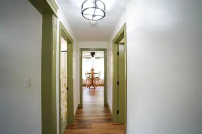 a hallway with green walls and a ceiling with a chandelier at Historic Sears River Home (Main Level) on 10 Acres in Tamaqua