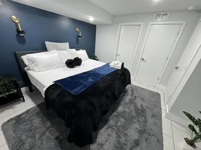 a bedroom with a large bed with white sheets and blue walls at Yanne's Place - Philabundance Views in Philadelphia