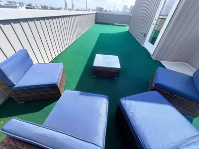 a balcony with two chairs and a table and green floor at Yanne's Place - Philabundance Views in Philadelphia