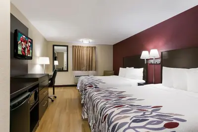 a hotel room with two beds and a desk at Red Roof Inn Hershey in Hershey
