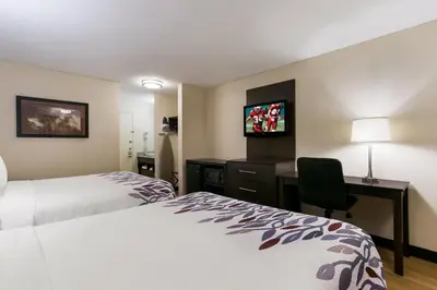 a hotel room with two beds and a desk at Red Roof Inn Hershey in Hershey