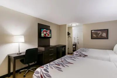 a hotel room with a bed and a desk and a tv at Red Roof Inn Hershey in Hershey