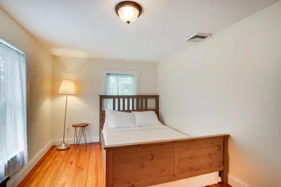 a bedroom with a bed and a lamp and a window at Peaceful Upstate New York Home with Yard and Fire Pit! in Walden