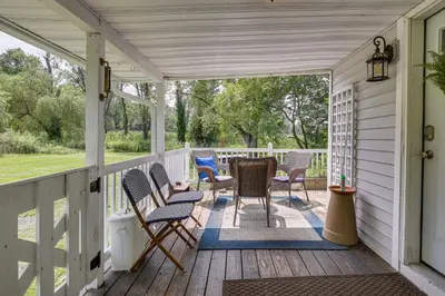 a porch with chairs and a table on it at Peaceful Upstate New York Home with Yard and Fire Pit! in Walden