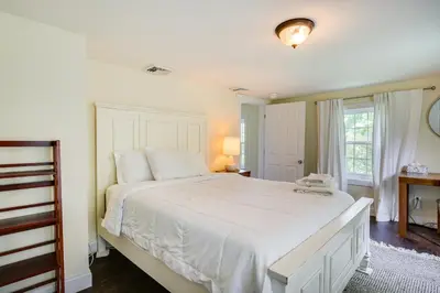 a bedroom with a large white bed and a window at Peaceful Upstate New York Home with Yard and Fire Pit! in Walden