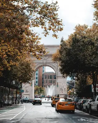 an orange taxi driving down a street in front of a bridge at ✪ Large 2 Bedrooms ✪ Queen Beds ✪ Work Stations in New York
