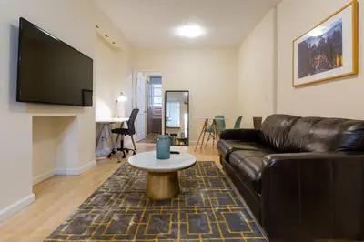 a living room with a leather couch and a table at Comfortable Apartment with Workstation in New York