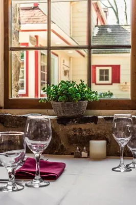 four wine glasses sitting on a table in front of a window at Joseph Ambler Inn in North Wales