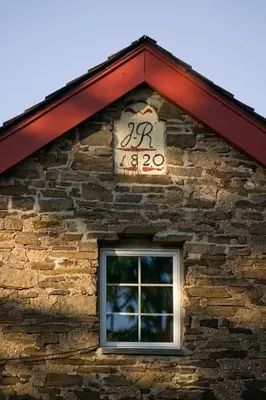 a sign on the side of a building with a window at Joseph Ambler Inn in North Wales