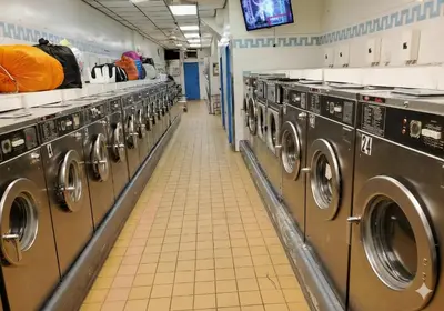 a row of washing machines in a laundry room at Comfortable 2BR & 2 Bath Apt in Downtown NYC in New York