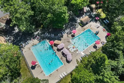 an overhead view of two swimming pools with umbrellas at Brentwood Burrow in East Stroudsburg
