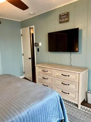 a bedroom with a bed and a flat screen tv at Lakeside Oasis with Kayaks, Hot Tub, & Fire Pit in Clifton