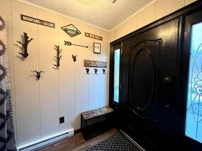 a hallway with a black door and someooky items on the wall at Lakeside Oasis with Kayaks, Hot Tub, & Fire Pit in Clifton