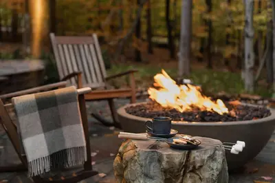 a fire pit with a cup of coffee on a stump at The Chatwal Lodge (All-Inclusive) - in The Unbound Collection by Hyatt in White Lake