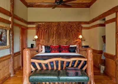 a bedroom with a wooden bed with red pillows at The Chatwal Lodge (All-Inclusive) - in The Unbound Collection by Hyatt in White Lake