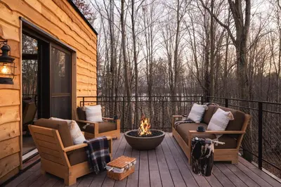 a screened in porch with a fire pit and two chairs at The Chatwal Lodge (All-Inclusive) - in The Unbound Collection by Hyatt in White Lake