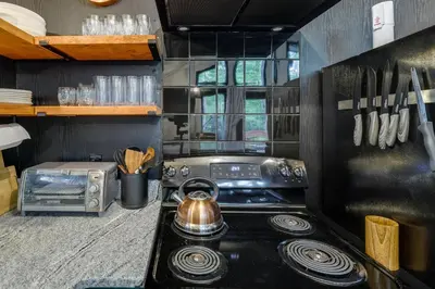 a kitchen with a stove and a tea kettle at Deck, Fire Pit and Sauna Big Bass Lake Getaway! in Clifton