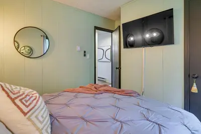 a bedroom with a bed with a round mirror at Deck, Fire Pit and Sauna Big Bass Lake Getaway! in Clifton