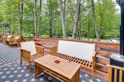 a patio with two chairs and a wooden table at Deck, Fire Pit and Sauna Big Bass Lake Getaway! in Clifton