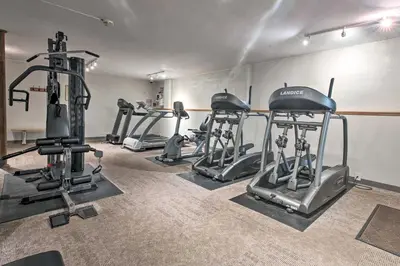 a gym with several tread machines in a room at Deck, Fire Pit and Sauna Big Bass Lake Getaway! in Clifton