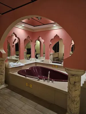 a bathroom with a purple tub in a pink room at Loop Inn Motel in Avenel