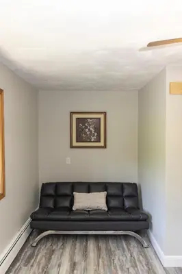 a black leather couch in a room with white walls at Stony Fork Inn in Wellsboro
