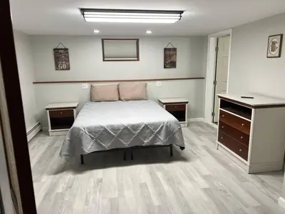 a bedroom with a bed and two dressers in it at Stony Fork Inn in Wellsboro