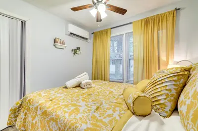 a bedroom with a bed with yellow sheets and a window at 5 Mi to Tobyhanna State Park Home with Game Room! in Tobyhanna