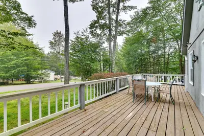 a wooden deck with a table and chairs on it at 5 Mi to Tobyhanna State Park Home with Game Room! in Tobyhanna