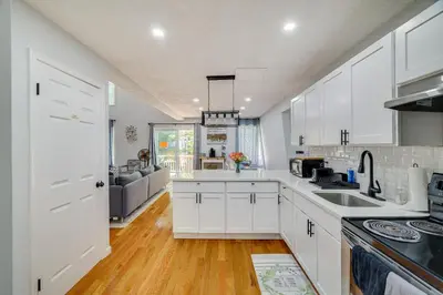 a kitchen with white cabinets and a sink at Community Perks Family Poconos Home with Deck! in Tobyhanna