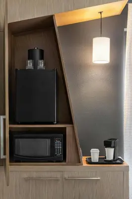 a room with a microwave and a tv on a shelf at Courtyard by Marriott Wilkes-Barre Arena in Wilkes-Barre