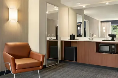 a waiting room with a chair and a television at Courtyard by Marriott Wilkes-Barre Arena in Wilkes-Barre