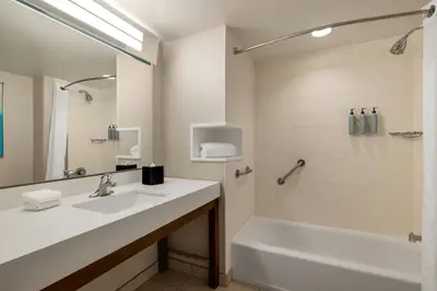 a bathroom with a tub and a sink and a bath tub at Courtyard by Marriott Wilkes-Barre Arena in Wilkes-Barre