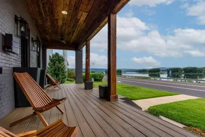 a porch with a bench and a view of the water at Sunset Stay at 608 in Wormleysburg