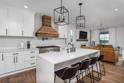 a kitchen with a large white island with bar chairs at Sunset Stay at 608 in Wormleysburg