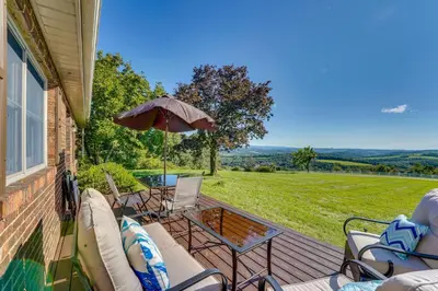 a deck with chairs and an umbrella on a house at Muncy Vacation Rental with Deck and Views in Muncy