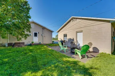 a patio with green chairs and a house at Muncy Vacation Rental with Deck and Views in Muncy