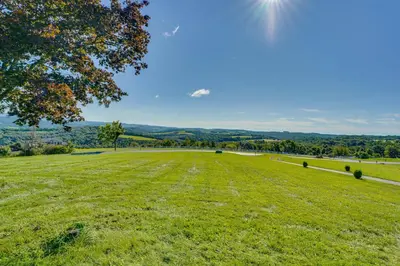 a large field of grass with a tree in the foreground at Muncy Vacation Rental with Deck and Views in Muncy