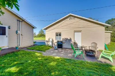 a backyard with a house with a grill and chairs at Muncy Vacation Rental with Deck and Views in Muncy