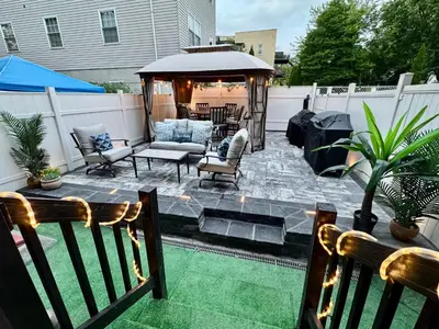 a backyard patio with a gazebo and chairs at 2 Bedroom Apartment, Close to NYC & Downtown JC! in Jersey City