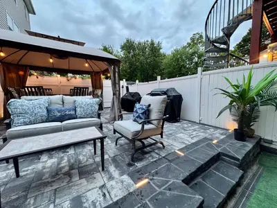 a patio with a couch and an umbrella at 2 Bedroom Apartment, Close to NYC & Downtown JC! in Jersey City