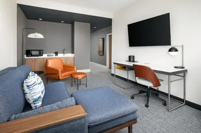 a living room with a couch and a desk with a computer at Courtyard by Marriott New Castle in New Castle