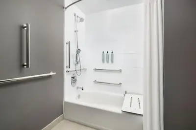 a bathroom with a shower and a white tub at Courtyard by Marriott New Castle in New Castle