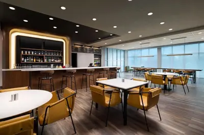 a restaurant with tables and chairs and a bar at Courtyard by Marriott New Castle in New Castle
