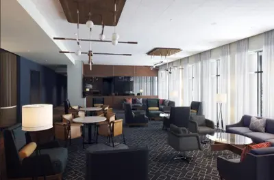 a lobby with couches and chairs and tables at Courtyard by Marriott New Castle in New Castle