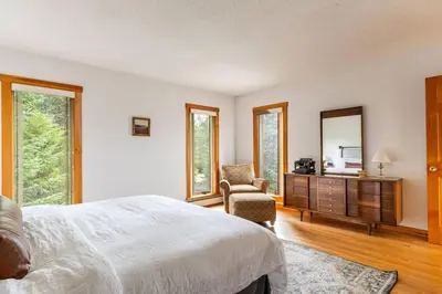 a bedroom with a bed and a chair and a mirror at Campbell Estates in Franklin