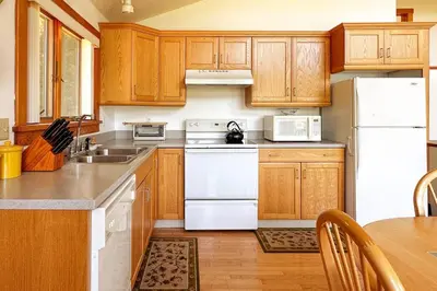 a kitchen with white appliances and wooden cabinets at Campbell Estates in Franklin