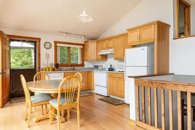 a kitchen with a table and chairs and a white refrigerator at Campbell Estates in Franklin